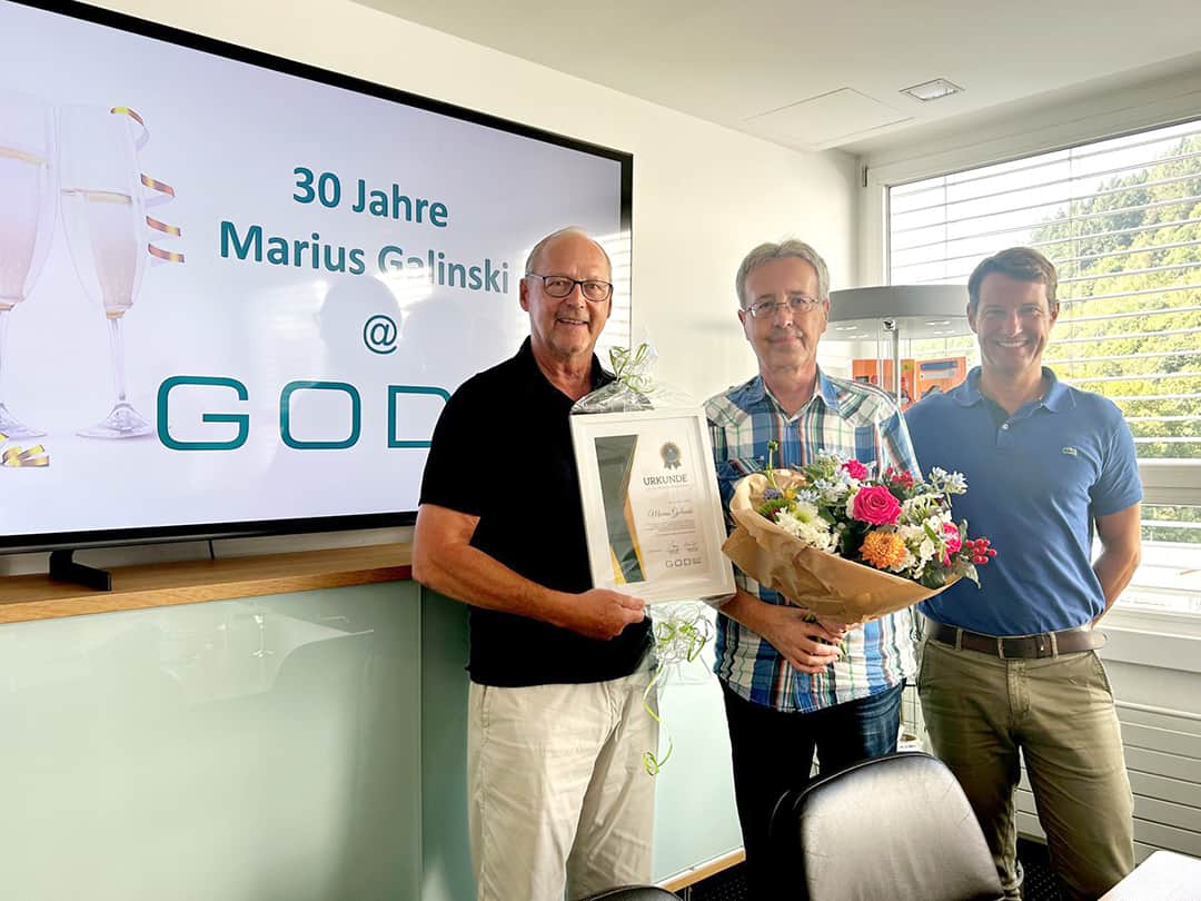 Markus Galinski steht in der Mitte, neben ihm Stefan Karp und Andreas Laib, die Ihm eine Urkunde und ein Präsent überreichen 